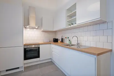 a kitchen with white cabinets and a sink at South Cosy Residence in Brussels
