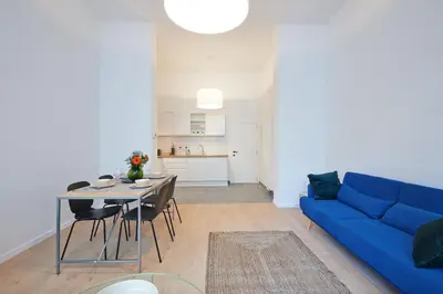 a living room with a blue couch and a table at South Cosy Residence in Brussels