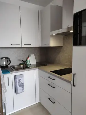 a white kitchen with white cabinets and a sink at Mathilde in Brussels