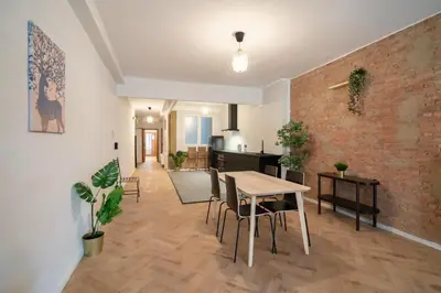 a living room with a table and chairs and a brick wall at Two-Bedroom Apartments in the Heart of Antwerp in Antwerp