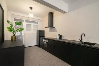 a kitchen with a black counter and a sink at Two-Bedroom Apartments in the Heart of Antwerp in Antwerp