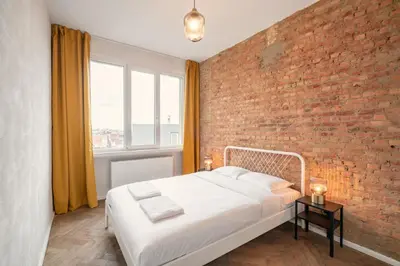 a bedroom with a brick wall and a bed at Two-Bedroom Apartments in the Heart of Antwerp in Antwerp