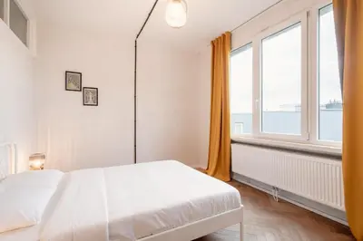 a bedroom with a bed and a large window at Two-Bedroom Apartments in the Heart of Antwerp in Antwerp