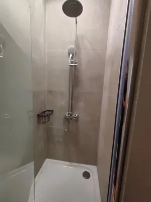 a bathroom with a shower with a glass door at QUARTIER LOUISE STUDIOS in Brussels