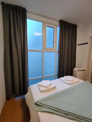 a bedroom with a bed and a large window at QUARTIER LOUISE STUDIOS in Brussels