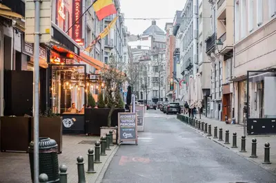 an empty city street with buildings and a street sign at QUARTIER LOUISE STUDIOS in Brussels