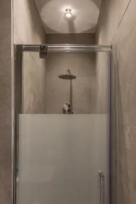 a shower with a glass door in a bathroom at QUARTIER LOUISE STUDIOS in Brussels