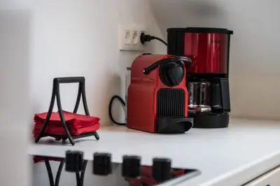 a red toaster sitting on top of a kitchen counter at QUARTIER LOUISE STUDIOS in Brussels