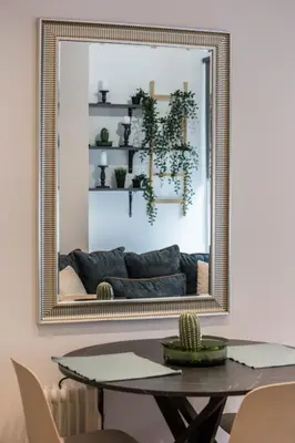 a mirror in a dining room with a table and a couch at QUARTIER LOUISE STUDIOS in Brussels