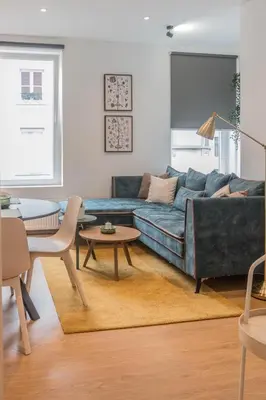 a living room with a blue couch and a table at QUARTIER LOUISE STUDIOS in Brussels