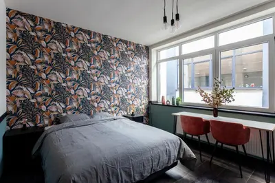 a bedroom with a bed and a table and a window at Hey - Aparthotel Brussels in Brussels