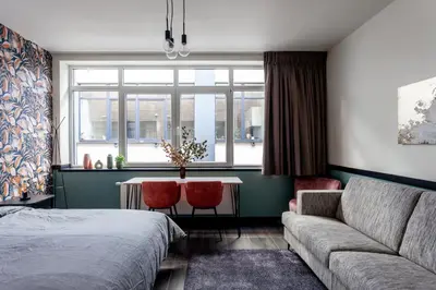 a living room with a couch and a table and a bed at Hey - Aparthotel Brussels in Brussels
