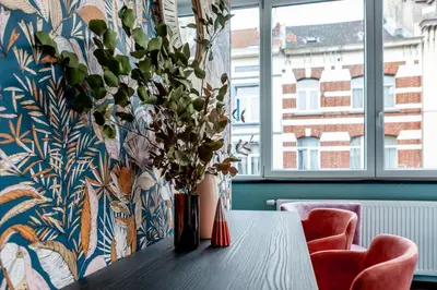 a table with a vase with a plant on it at Hey - Aparthotel Brussels in Brussels