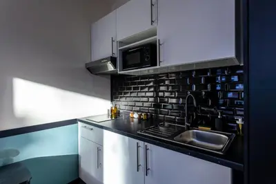 a kitchen with a sink and a microwave at Hey - Aparthotel Brussels in Brussels
