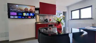 a kitchen with a glass table and a refrigerator at Logeerkamer XXL 25 m2 in Zemst