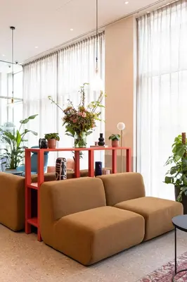 a living room with a couch and a table at B&B HOTEL Mechelen in Mechelen