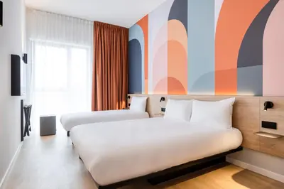 a hotel room with two beds and a window at B&B HOTEL Mechelen in Mechelen
