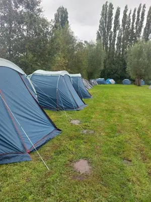 a row of blue tents in a field at Luxury Pop Up Camping & Hotel Package & Private Transport to Tomorrowland in Schelle