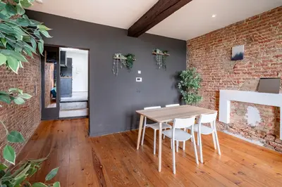 a dining room with a table and a brick wall at Two-Bedroom River Side Apartment in the Heart of Antwerp in Antwerp