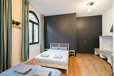 a bedroom with two beds and a large window at Two-Bedroom River Side Apartment in the Heart of Antwerp in Antwerp