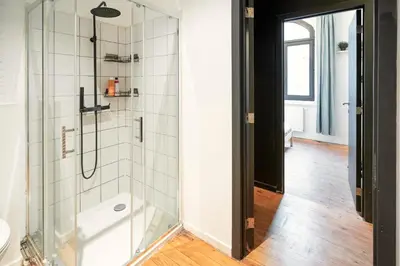 a bathroom with a shower with a glass door at Two-Bedroom River Side Apartment in the Heart of Antwerp in Antwerp