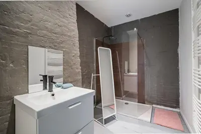 a bathroom with a white sink and a shower at Two-Bedroom River Side Apartment in the Heart of Antwerp in Antwerp