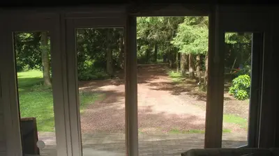 an open glass door with a view of a driveway at Mezenhof in Brasschaat