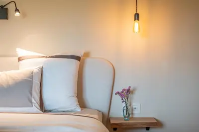 a bedroom with a bed with a vase of flowers on a table at B&B 't Kloosterveld in Boutersem