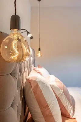 a lamp hanging over a couch with pillows at B&B 't Kloosterveld in Boutersem