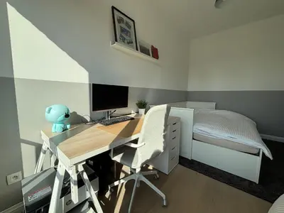 a bedroom with a desk with a computer and a bed at Luxury apartment, private terrace & FREE PARKING in Antwerp