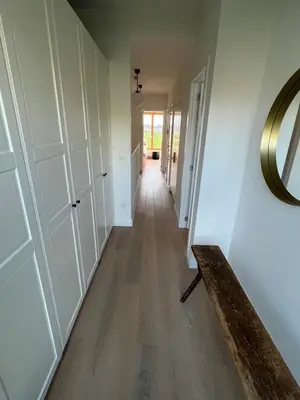 a hallway in a house with white walls and wooden floors at Luxury apartment, private terrace & FREE PARKING in Antwerp