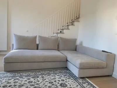 a couch in a living room with a staircase at Luxury apartment, private terrace & FREE PARKING in Antwerp