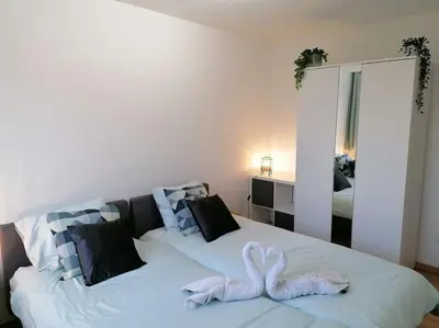 a white bed with two white swans on it at The Corner in Retie