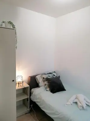 a bedroom with a bed with a black pillow and a table at The Corner in Retie