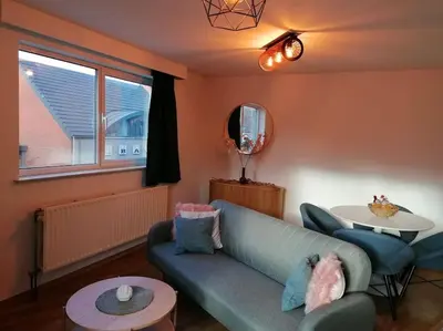 a living room with a blue couch and a table at The Corner in Retie