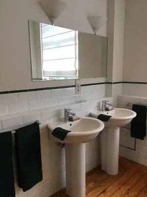 a bathroom with two sinks and a mirror at Overijse’s cosiest double room in Overijse