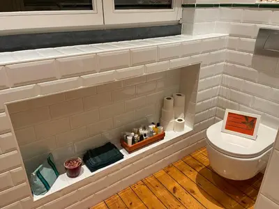 a bathroom with a toilet in a brick wall at Overijse’s cosiest double room in Overijse