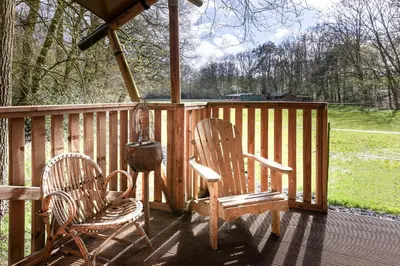 two chairs and a grill on a wooden deck at de Swaenhoeve in Zoersel