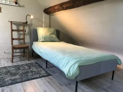 a small bed in a room with a stair at de Swaenhoeve in Zoersel
