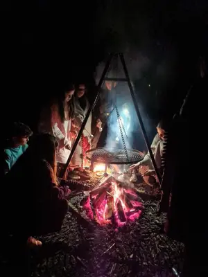 a group of people standing around a fire at night at de Swaenhoeve in Zoersel