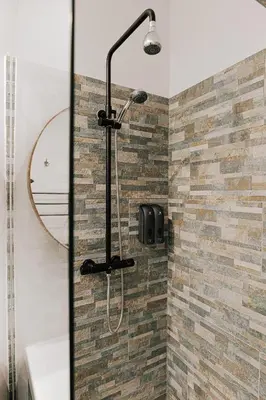 a shower in a bathroom with a brick wall at Cozy Apartment in Brussels in Brussels