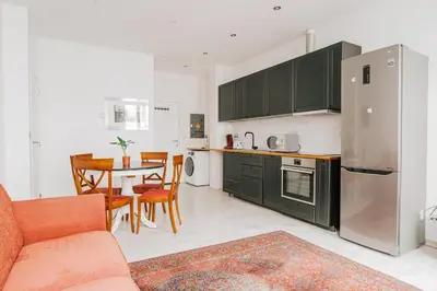 a kitchen and dining room with a couch and a table at Cozy Apartment in Brussels in Brussels