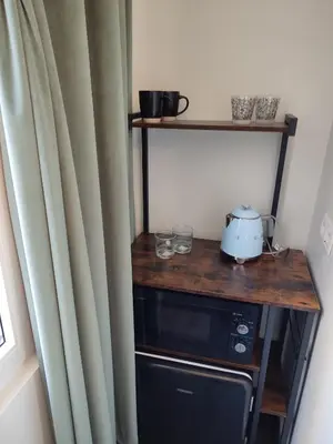 a kitchen with a table and a microwave and a curtain at Studio Anvers in Antwerp