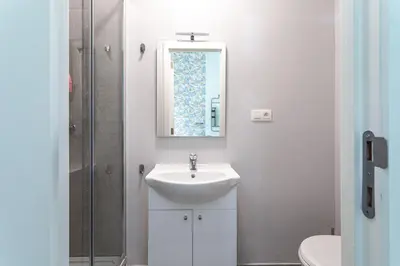 a white bathroom with a sink and a mirror at Studio Anvers in Antwerp