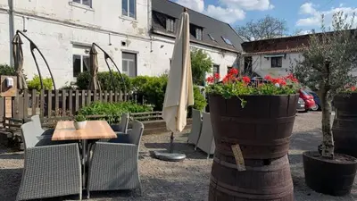 a patio with a table and an umbrella and flowers at Sweet Dreams by Pegase in Vlezenbeek