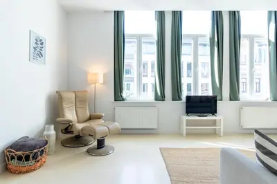 a living room with a couch and chairs and windows at Bright, Spacious Apartments & Perfectly Located in the Heart of Ghent in Ghent