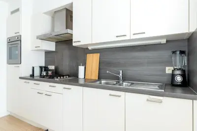 a kitchen with white cabinets and a sink at Bright, Spacious Apartments & Perfectly Located in the Heart of Ghent in Ghent