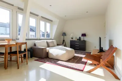 a living room with a couch and a table at Bright, Spacious Apartments & Perfectly Located in the Heart of Ghent in Ghent