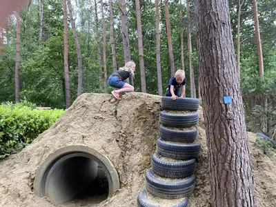 two children playing on a pile of tires at Camping het Swinnenbos in Diest