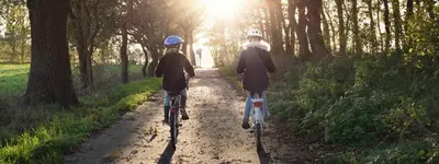 two people riding bikes down a dirt trail at Camping het Swinnenbos in Diest